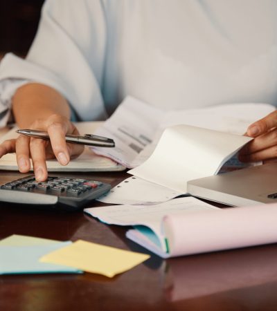 Hands of female entrepreneur working with bills and documents